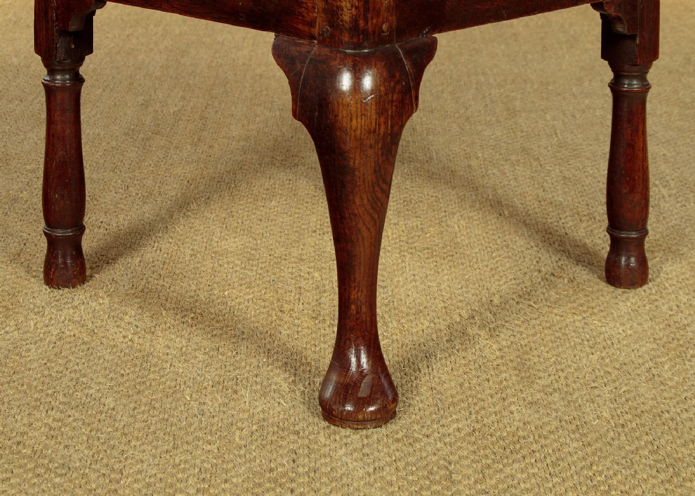 An eighteenth-century dark oak corner armchair featuring a curved top rail, two pierced splats, a patterned drop-in seat, and a central cabriole front leg. View VIII
