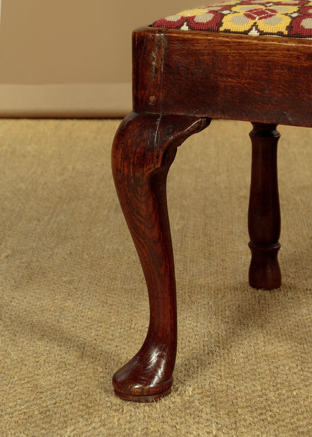 An eighteenth-century dark oak corner armchair featuring a curved top rail, two pierced splats, a patterned drop-in seat, and a central cabriole front leg. View IX