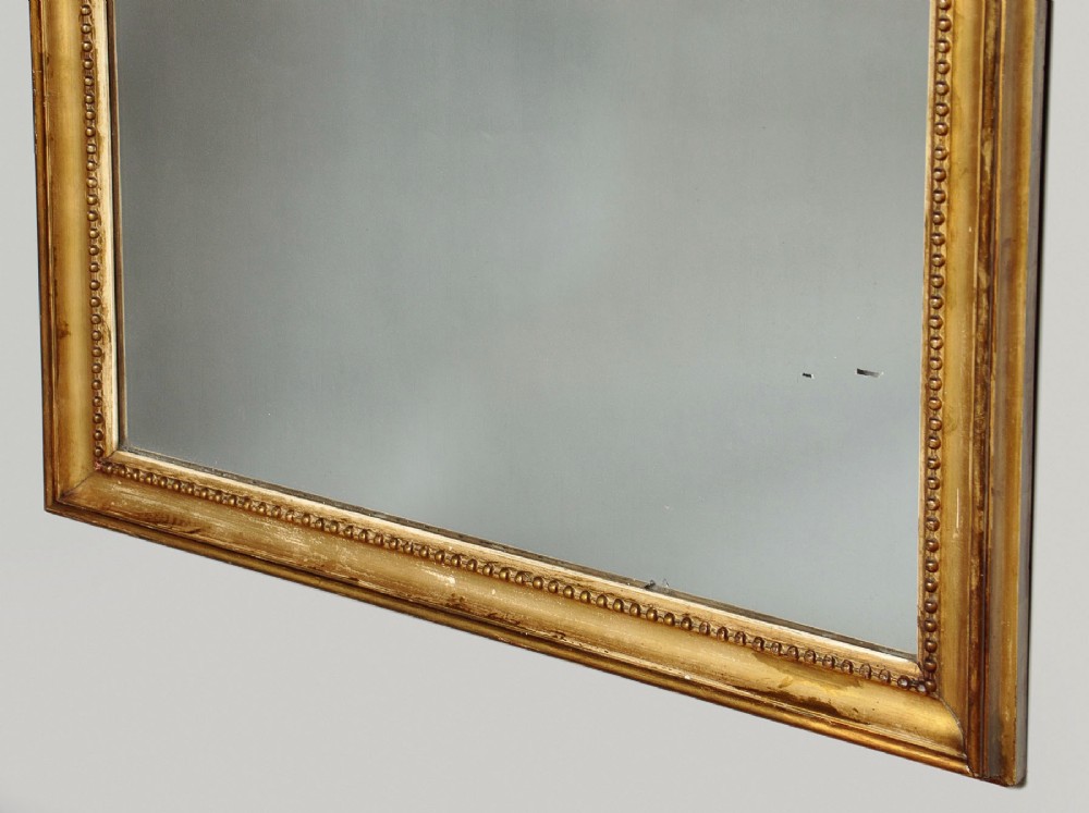 A large late Victorian giltwood overmantel mirror with an arched top, detailed beaded inner rim, and carved cresting featuring acanthus scrollwork. View VII