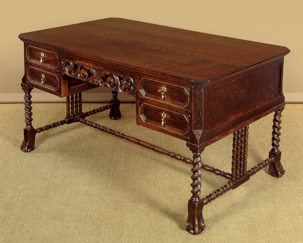 A dark carved oak writing desk featuring four geometric drawers, a scroll-carved central frieze, barley-twist legs, and a stretcher base. View III