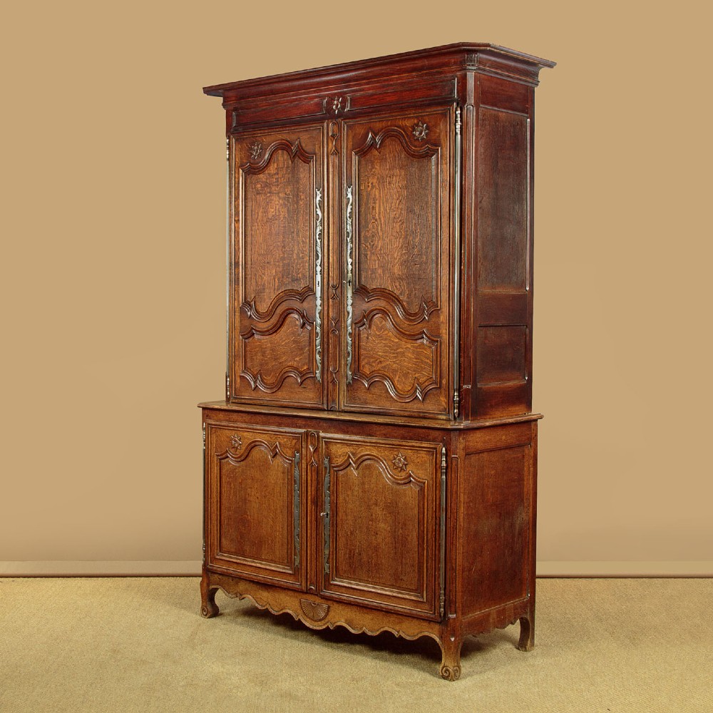 An 18th-century French provincial oak housekeepers cupboard featuring two upper and two lower moulded panel doors with carved star motifs and cabriole feet. View III