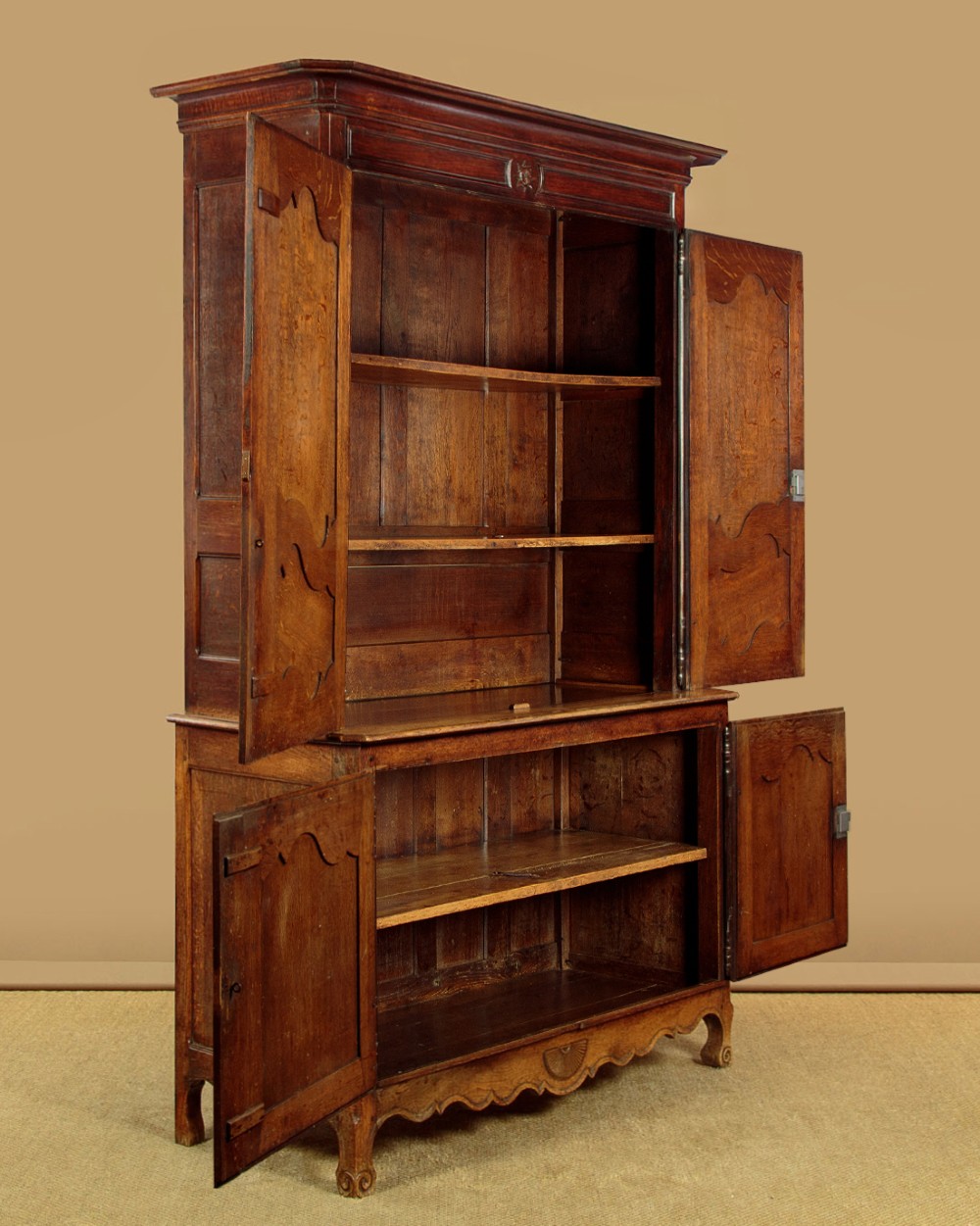 An 18th-century French provincial oak housekeepers cupboard featuring two upper and two lower moulded panel doors with carved star motifs and cabriole feet. View IV