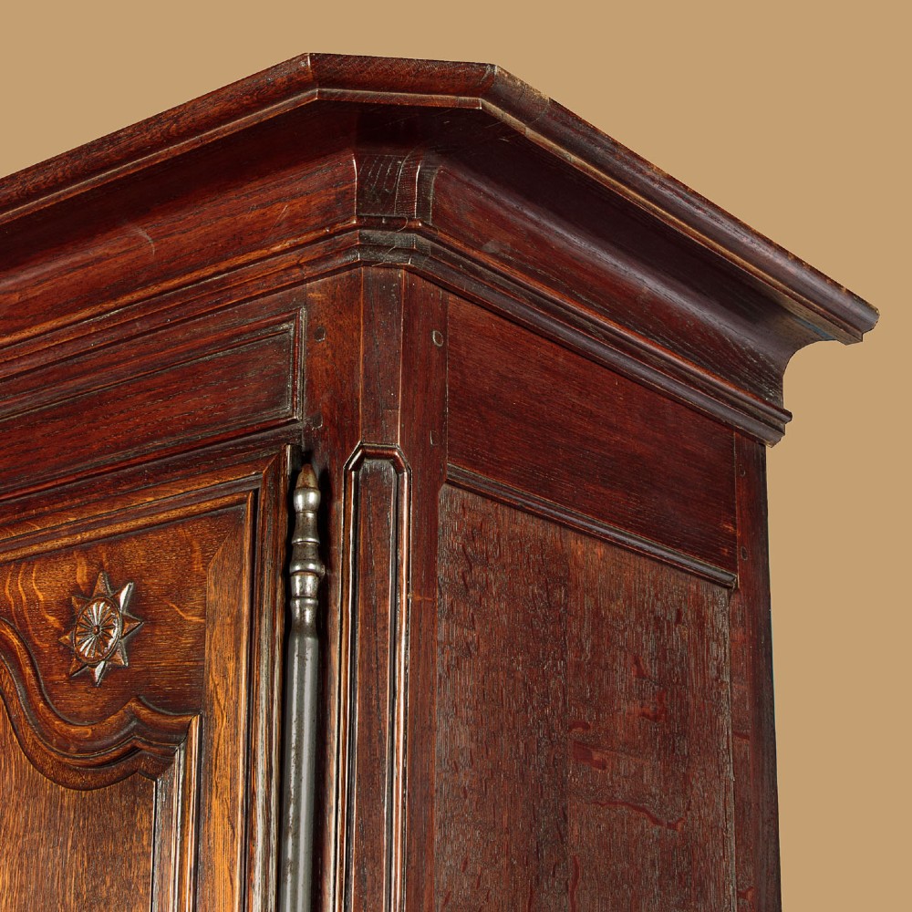 An 18th-century French provincial oak housekeepers cupboard featuring two upper and two lower moulded panel doors with carved star motifs and cabriole feet. View VI