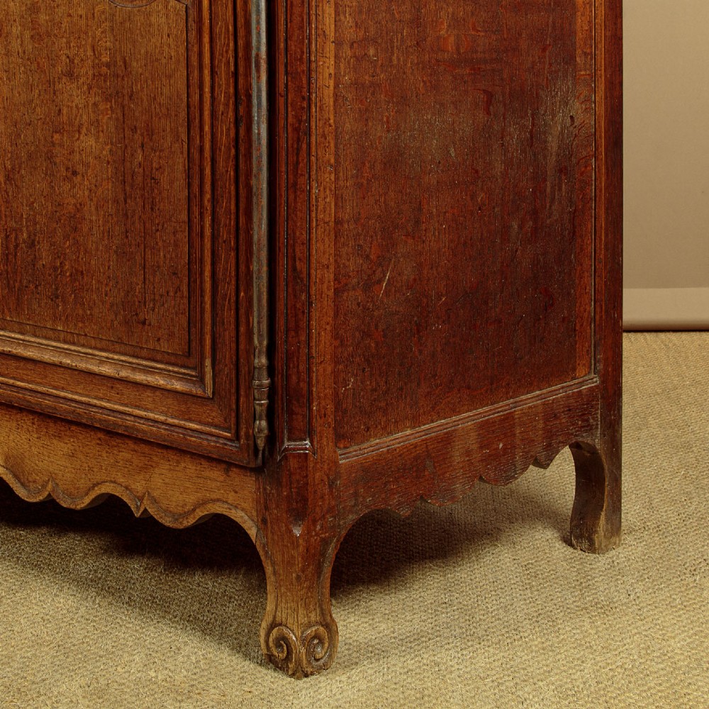 An 18th-century French provincial oak housekeepers cupboard featuring two upper and two lower moulded panel doors with carved star motifs and cabriole feet. View XIII