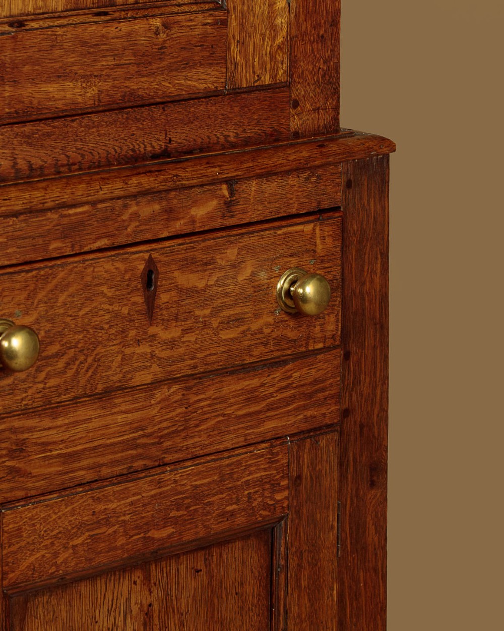A two-part antique warm brown oak bread and cheese cupboard featuring upper doors with lattice ventilation fretwork over lower drawers and panelled cupboard doors. View XIII
