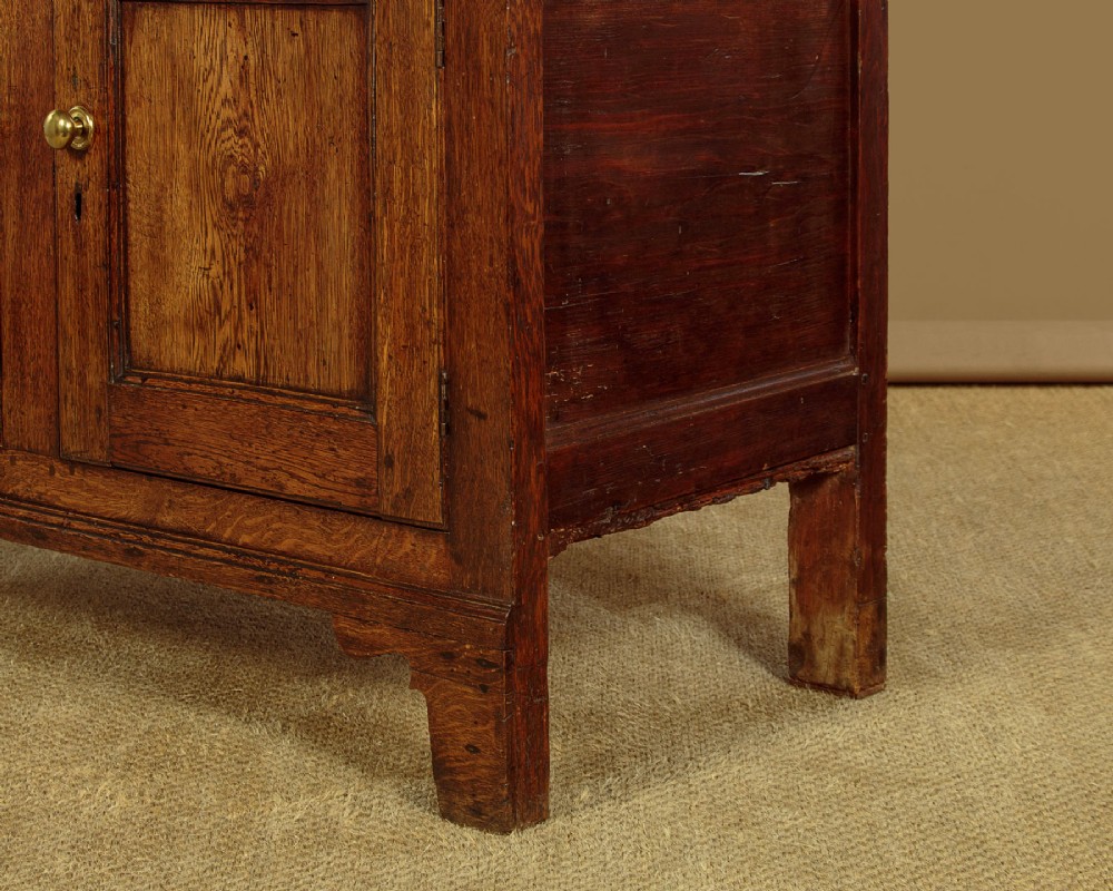 A two-part antique warm brown oak bread and cheese cupboard featuring upper doors with lattice ventilation fretwork over lower drawers and panelled cupboard doors. View XIV