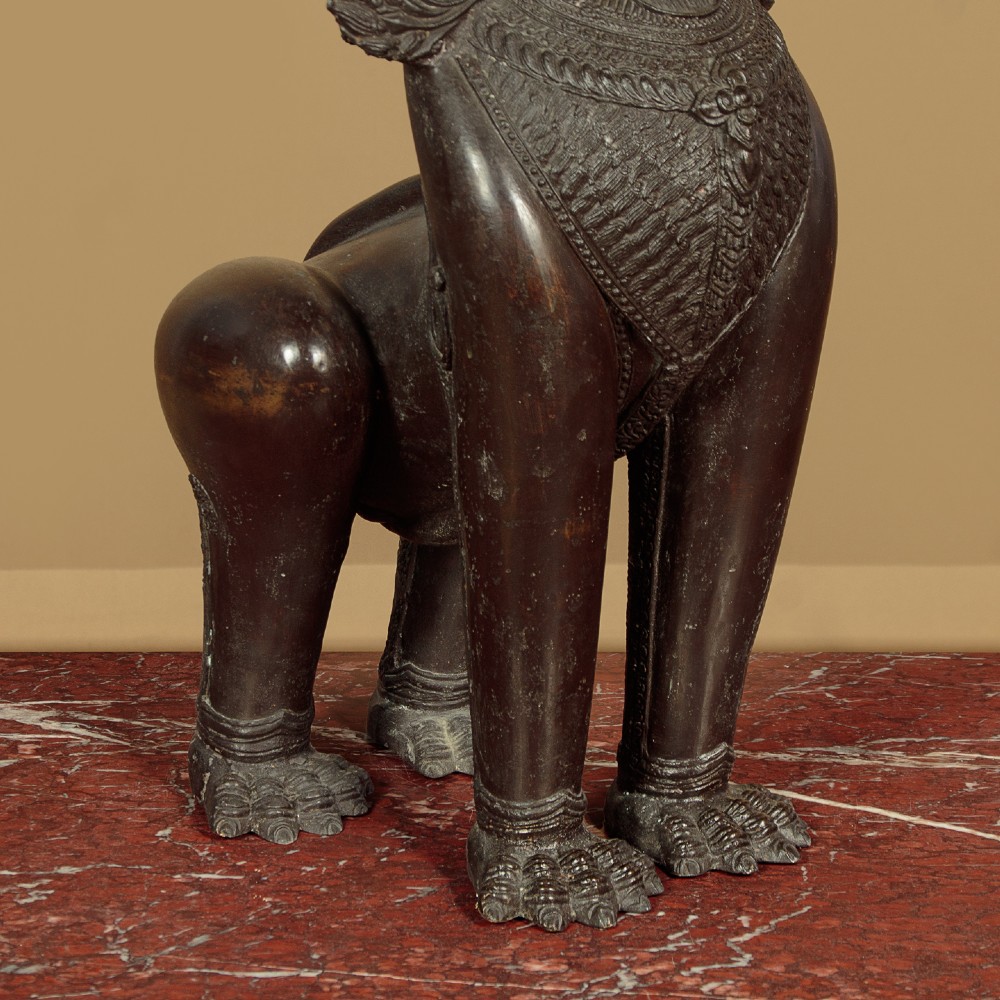 A pair of dark bronze temple lion statues sitting upright with intricate stylized manes and detailed ornamental chest bands. View XI