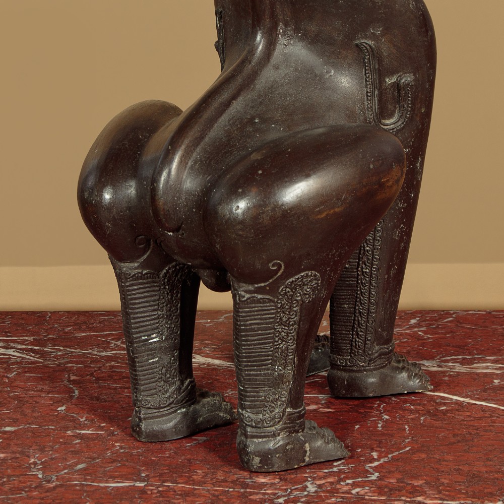 A pair of dark bronze temple lion statues sitting upright with intricate stylized manes and detailed ornamental chest bands. View XII