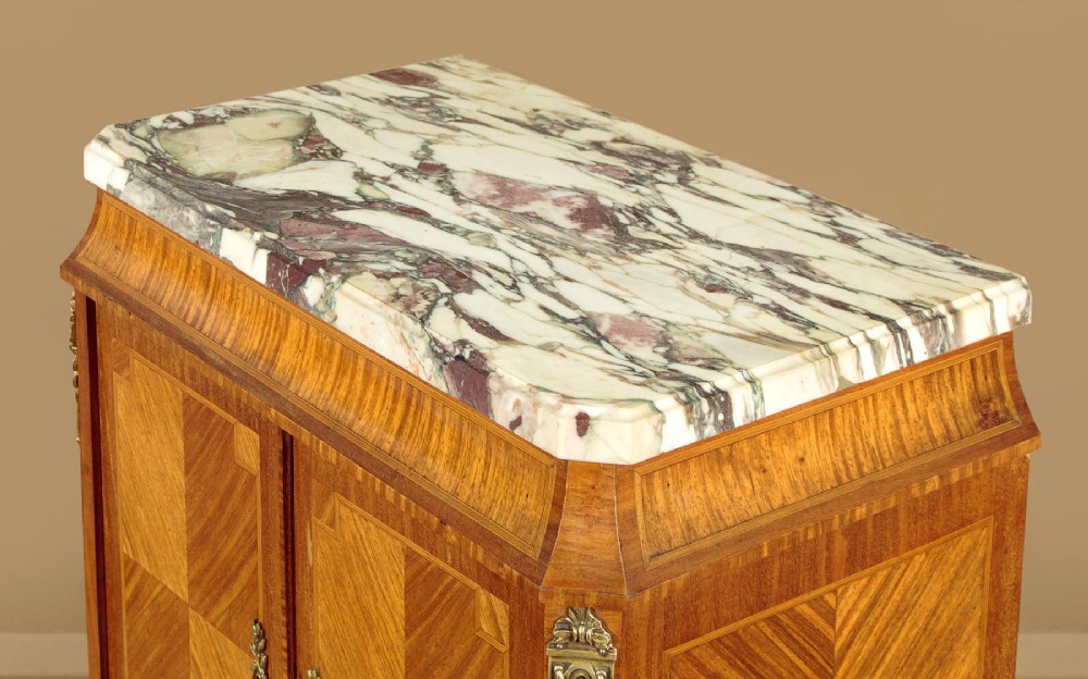 A tall Louis XVI style wooden side cabinet featuring geometric herringbone parquetry veneers, brass mounts, and a polished marble top. View VI