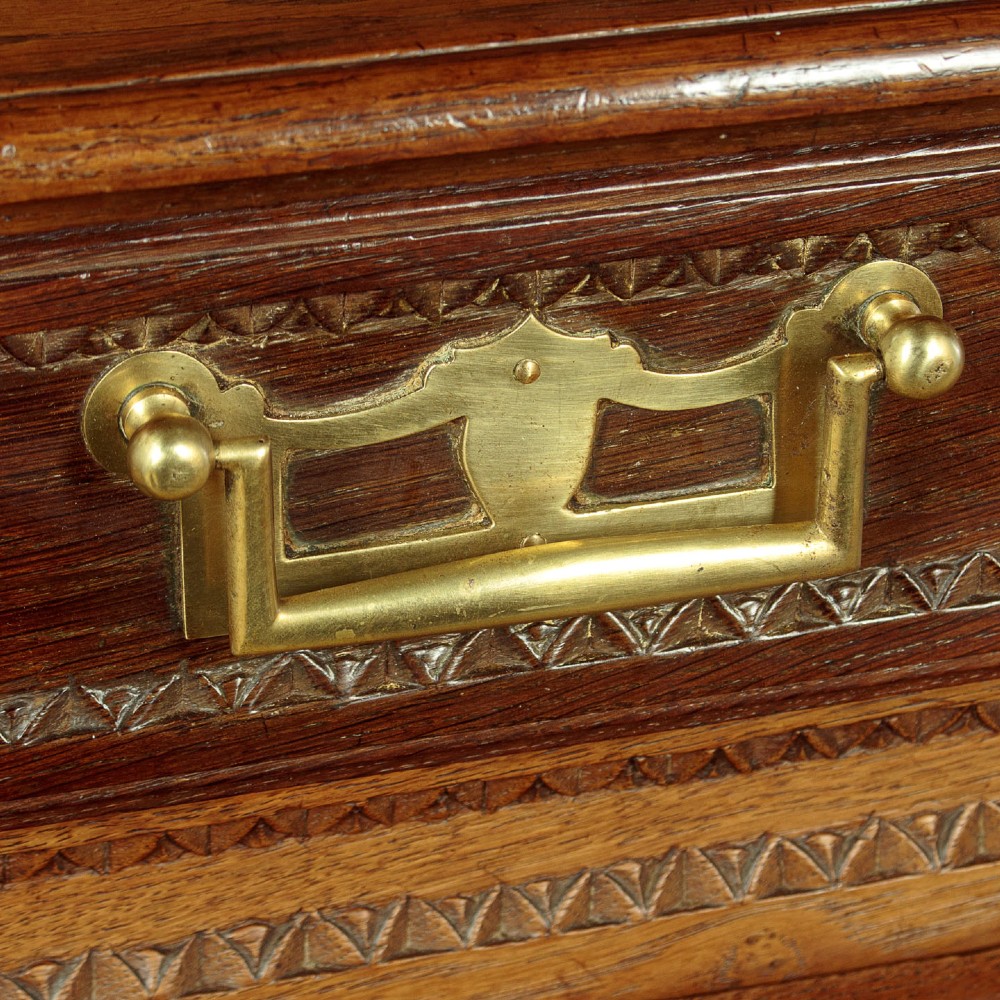 A late 18th-century French oak dresser base featuring two drawers above carved panelled cupboard doors with brass hardware. View VII