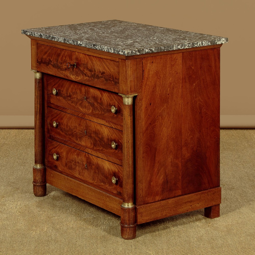 An Empire style mahogany chest of four drawers featuring a grey marble top, brass pull handles, and side column pillars. View II