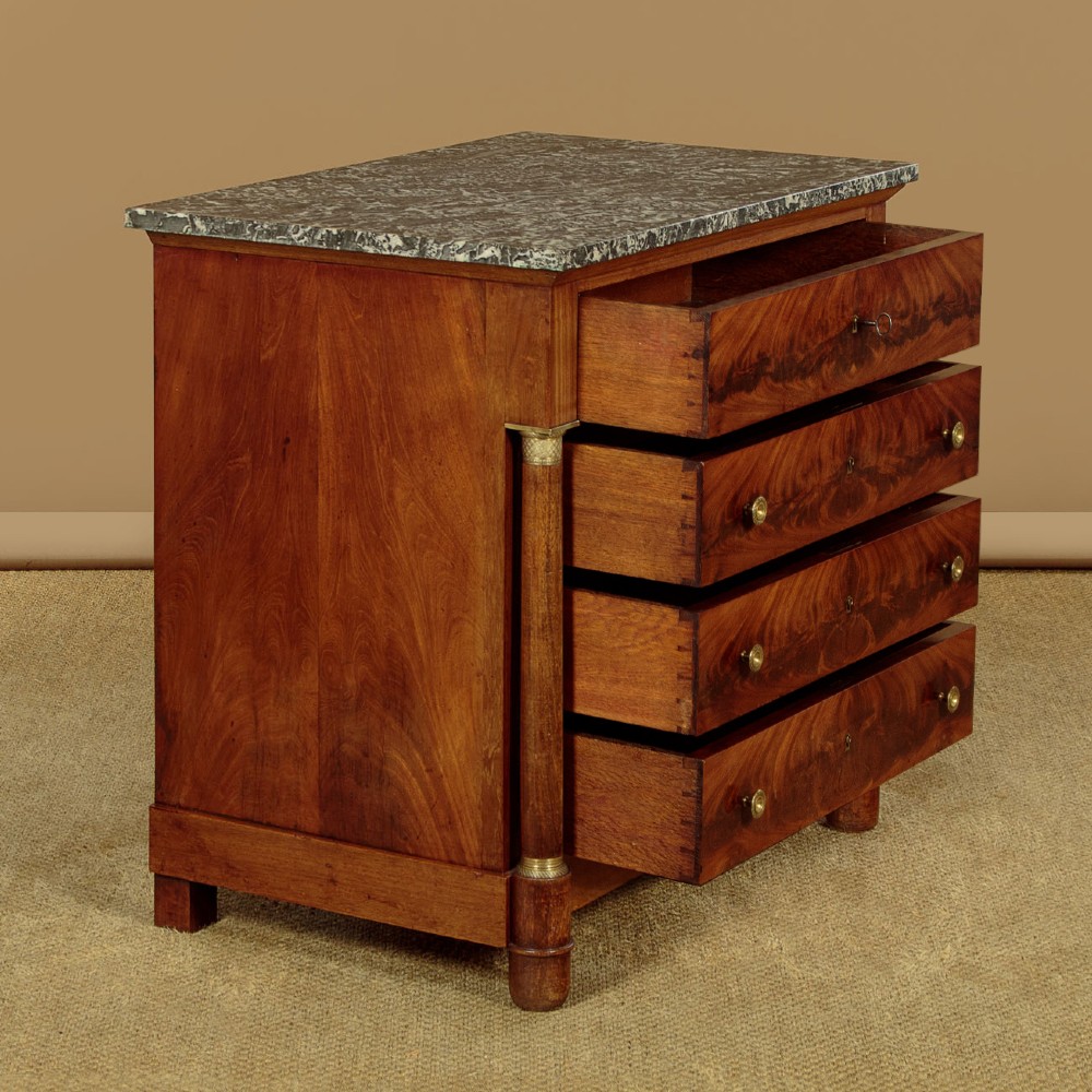 An Empire style mahogany chest of four drawers featuring a grey marble top, brass pull handles, and side column pillars. View III