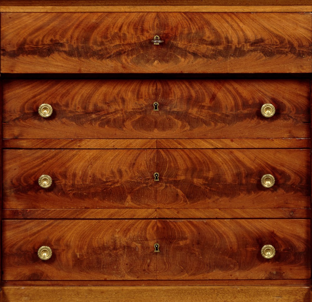 An Empire style mahogany chest of four drawers featuring a grey marble top, brass pull handles, and side column pillars. View VI