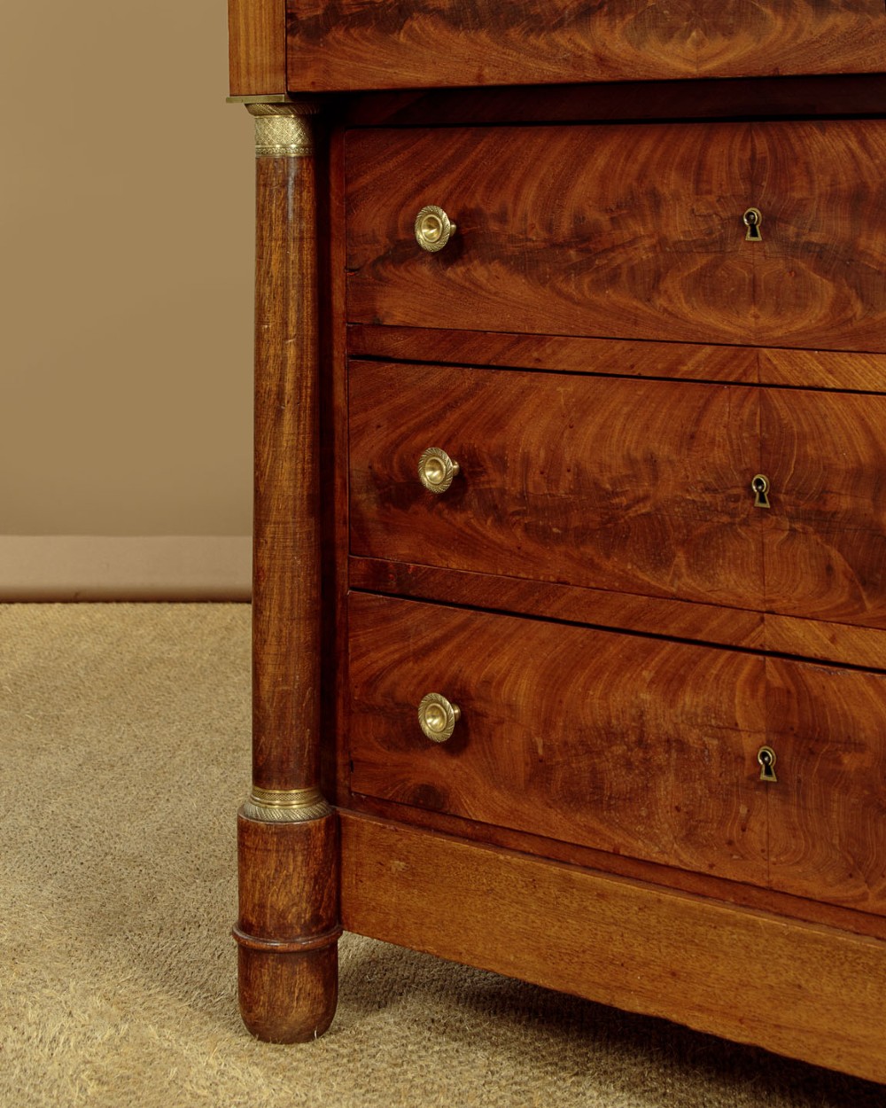 An Empire style mahogany chest of four drawers featuring a grey marble top, brass pull handles, and side column pillars. View VIII
