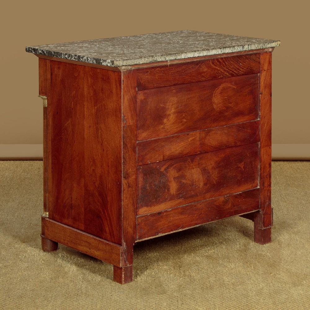 An Empire style mahogany chest of four drawers featuring a grey marble top, brass pull handles, and side column pillars. View XI