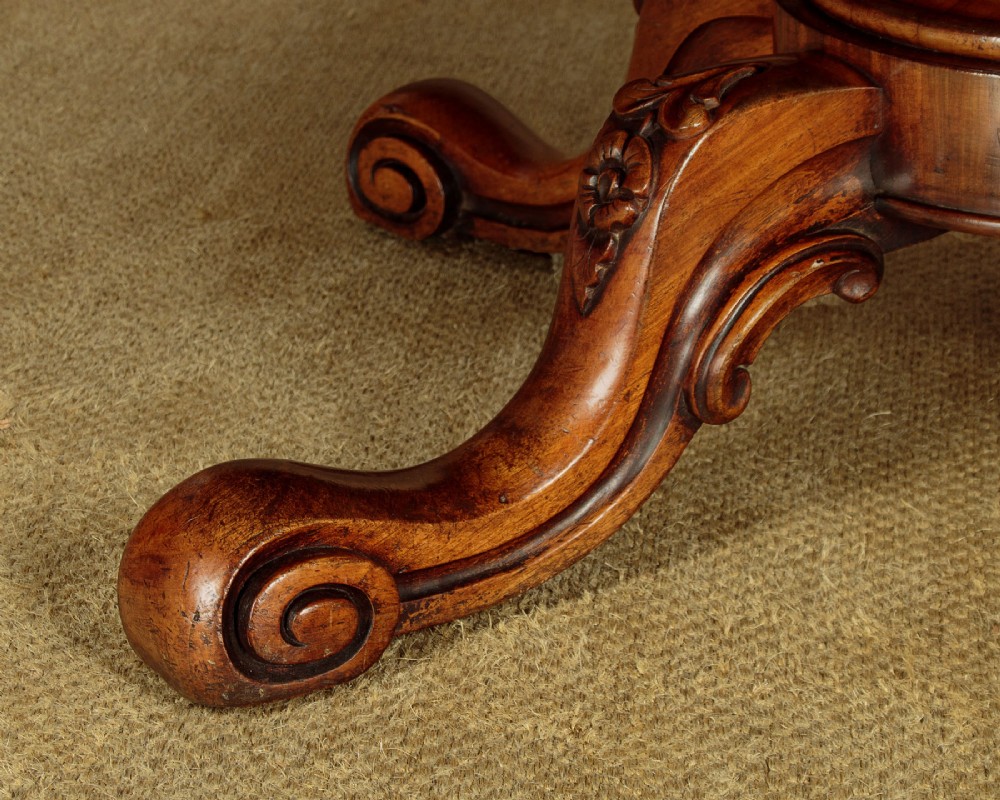 A large Victorian mahogany oval coffee table featuring a polished top, a deep apron, and a carved quadruped pedestal base with scroll feet. View X
