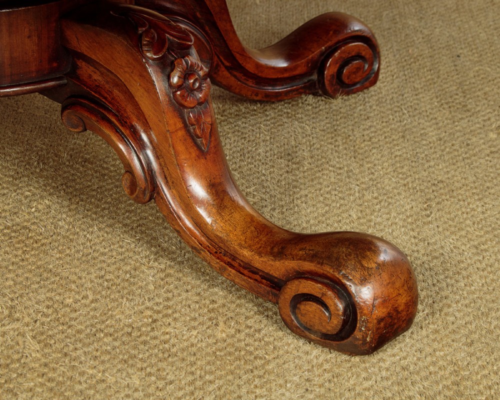 A large Victorian mahogany oval coffee table featuring a polished top, a deep apron, and a carved quadruped pedestal base with scroll feet. View XI