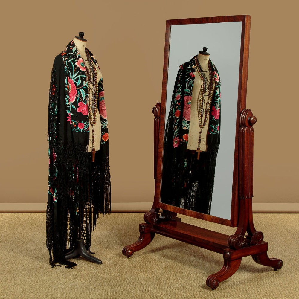 A 19th-century mahogany cheval mirror featuring a rectangular swivelling glass frame set between carved reeded uprights on scroll feet. View II