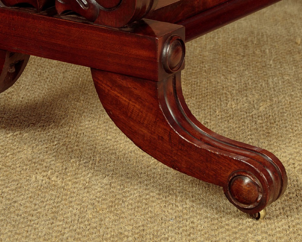 A 19th-century mahogany cheval mirror featuring a rectangular swivelling glass frame set between carved reeded uprights on scroll feet. View IX
