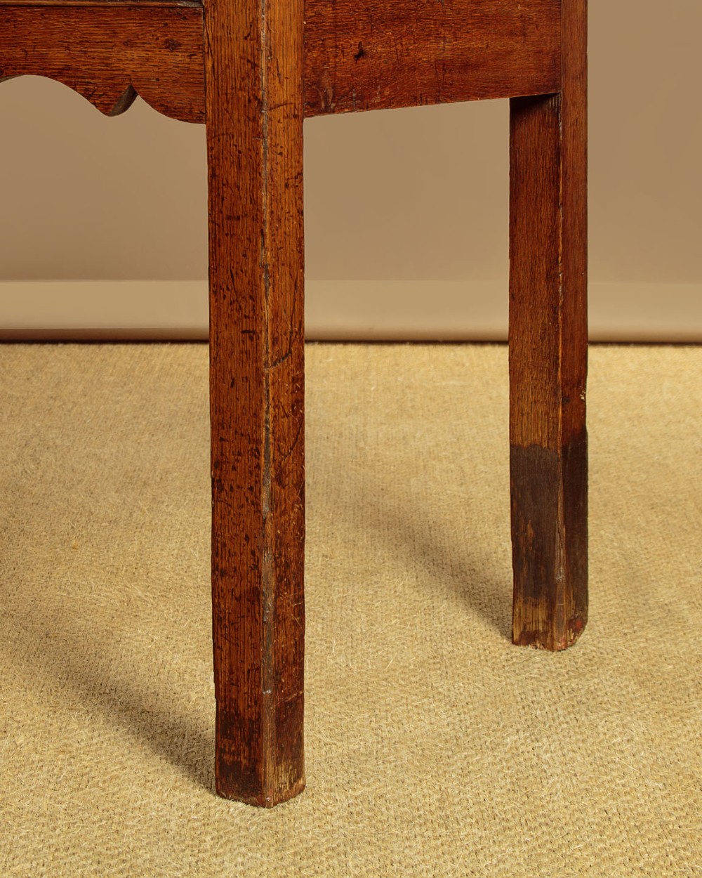 An 18th-century long oak dresser base featuring four drawers with brass swan-neck handles, a scalloped lower apron, and straight square legs. View IX