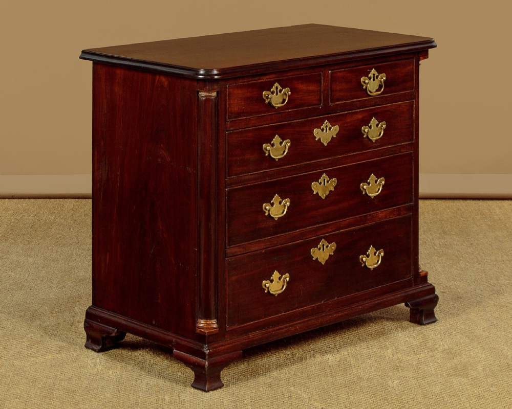 A small Georgian mahogany chest of drawers featuring two short and three long graduated drawers with brass batwing backplate handles and bracket feet. View II
