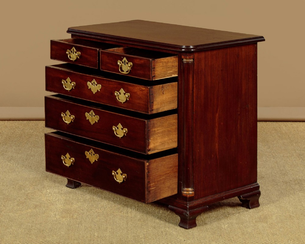 A small Georgian mahogany chest of drawers featuring two short and three long graduated drawers with brass batwing backplate handles and bracket feet. View IV