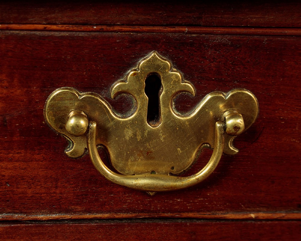 A small Georgian mahogany chest of drawers featuring two short and three long graduated drawers with brass batwing backplate handles and bracket feet. View VIII