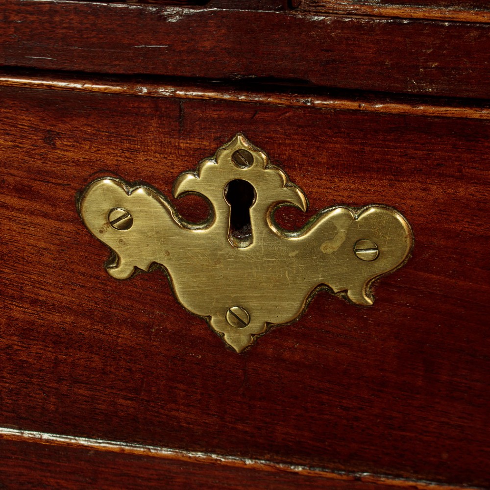 A small Georgian mahogany chest of drawers featuring two short and three long graduated drawers with brass batwing backplate handles and bracket feet. View IX