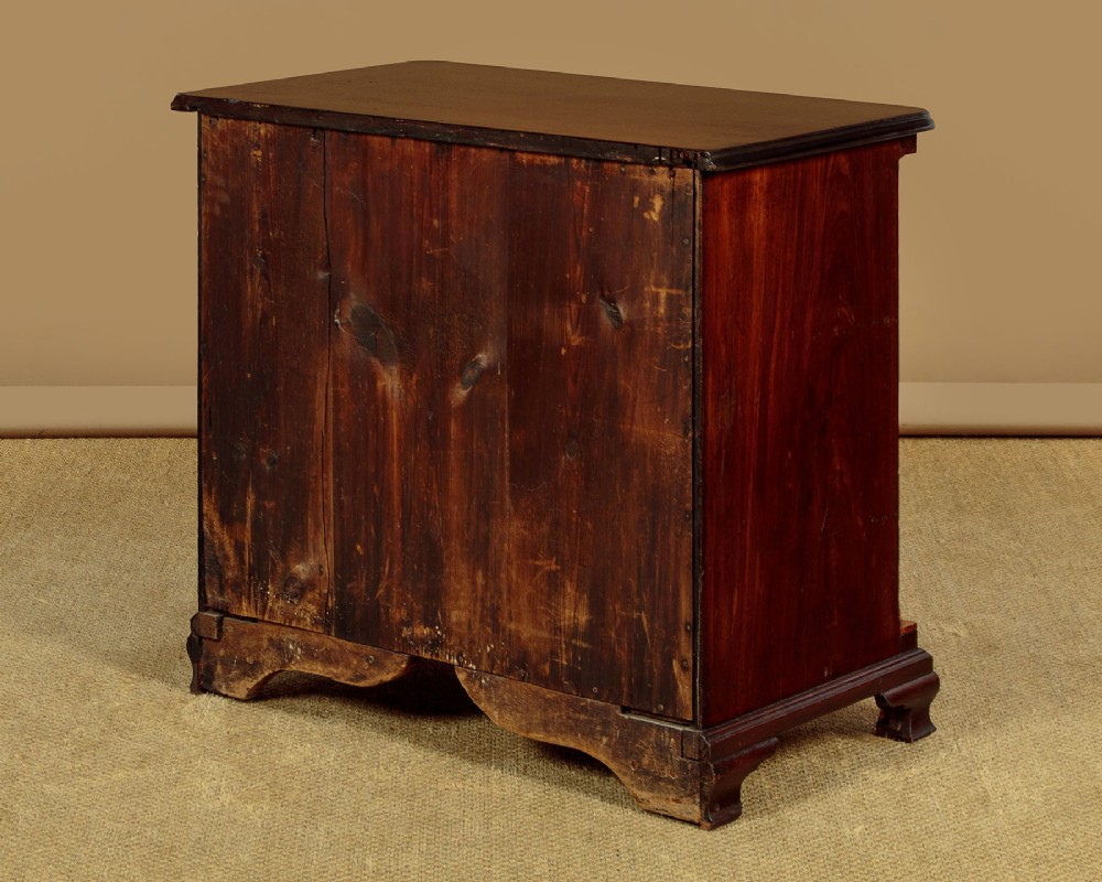 A small Georgian mahogany chest of drawers featuring two short and three long graduated drawers with brass batwing backplate handles and bracket feet. View XI