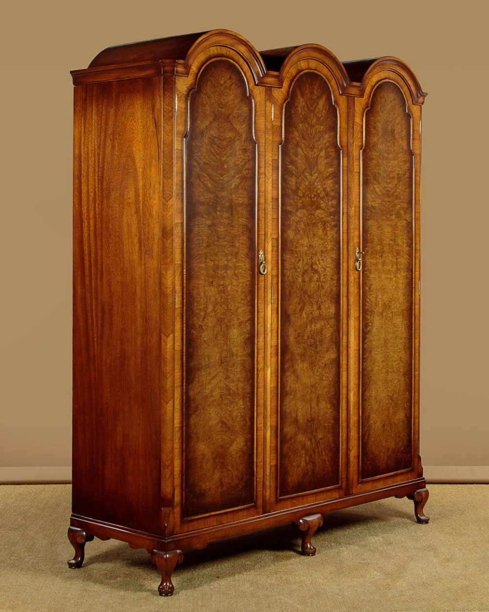 A 1920s Queen Anne style triple-door combination wardrobe made of figured burr walnut veneer with triple arched cornices and cabriole legs. View II