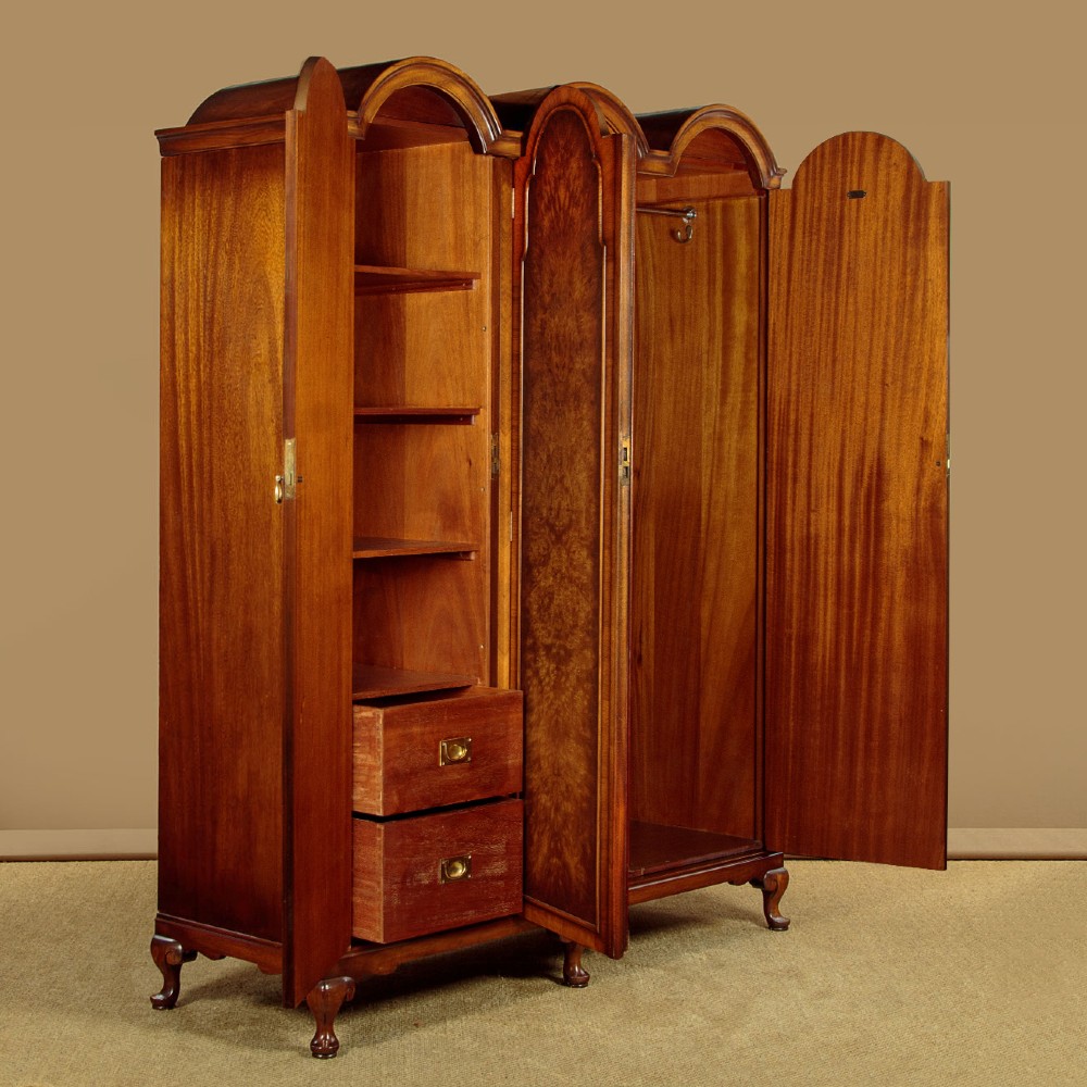 A 1920s Queen Anne style triple-door combination wardrobe made of figured burr walnut veneer with triple arched cornices and cabriole legs. View IV