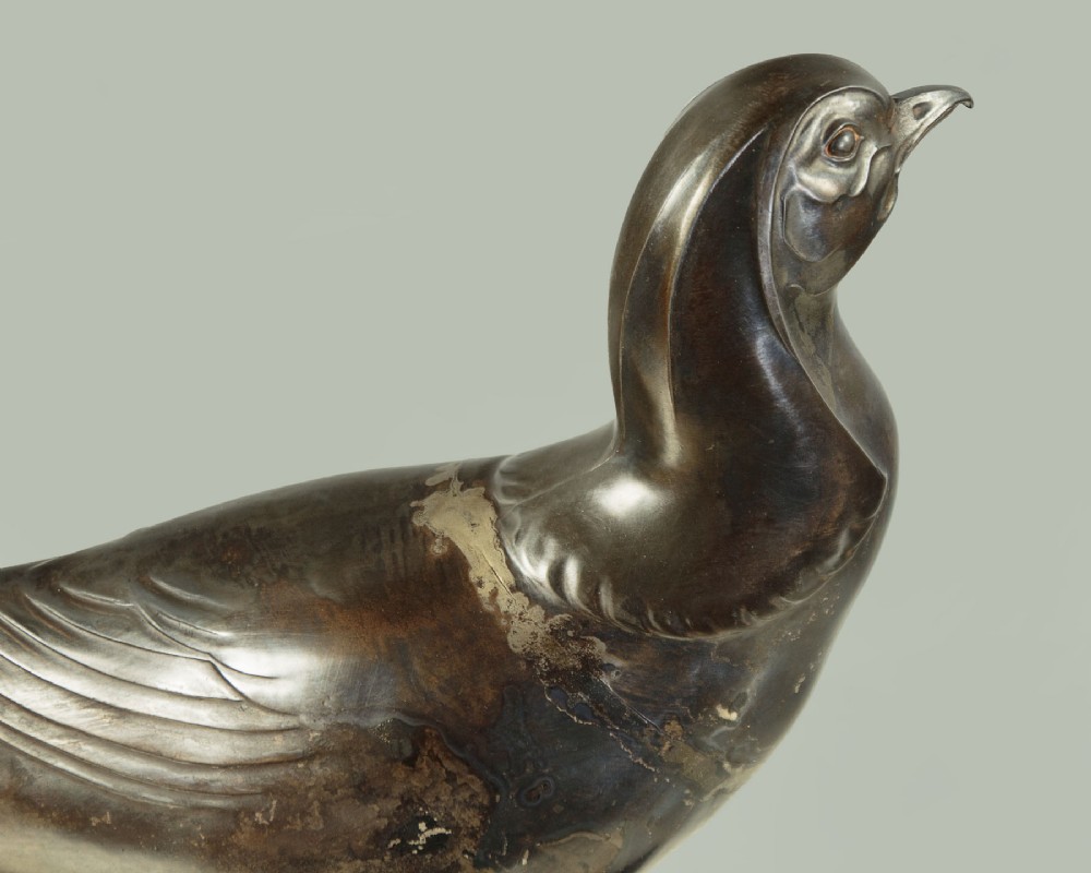 An Art Deco patinated metal sculpture of a long-tailed pheasant mounted on a rectangular black and gold marbled base. View V