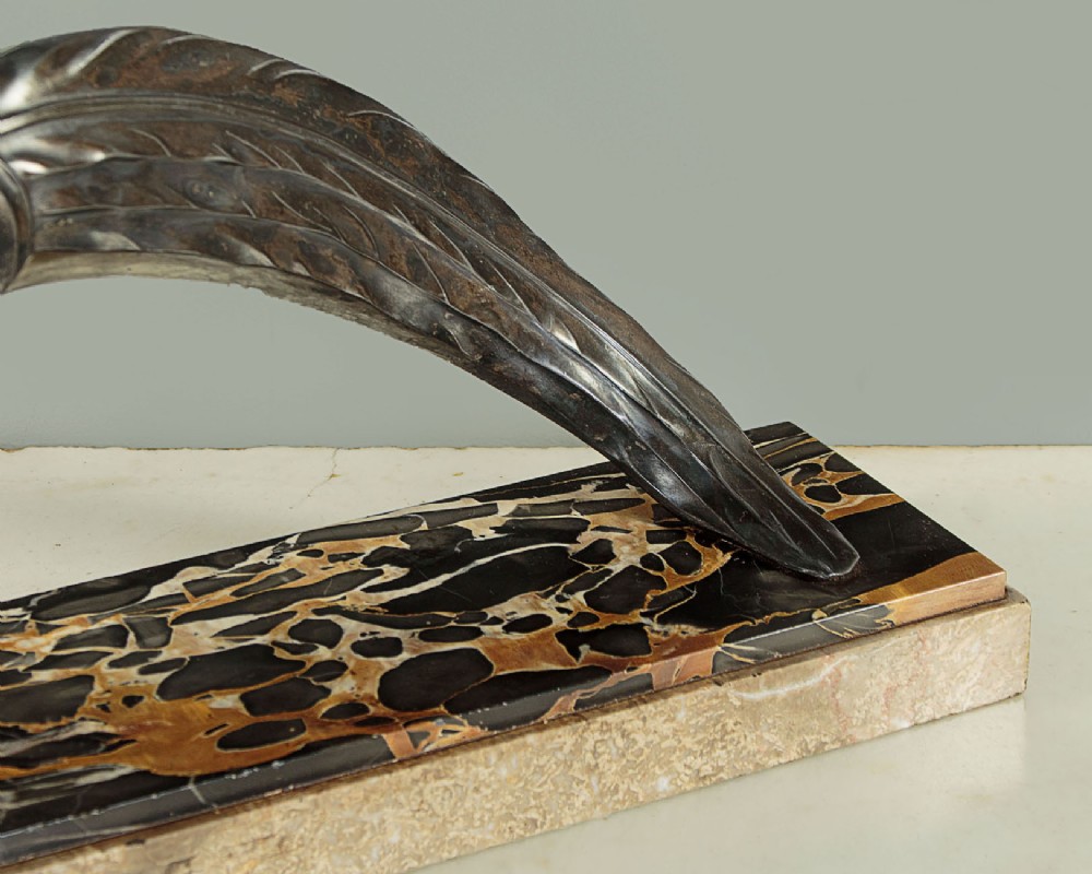 An Art Deco patinated metal sculpture of a long-tailed pheasant mounted on a rectangular black and gold marbled base. View VII