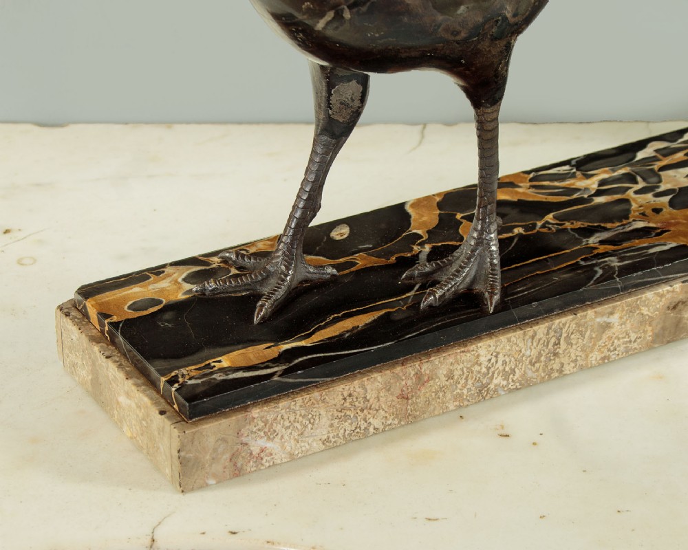 An Art Deco patinated metal sculpture of a long-tailed pheasant mounted on a rectangular black and gold marbled base. View VIII
