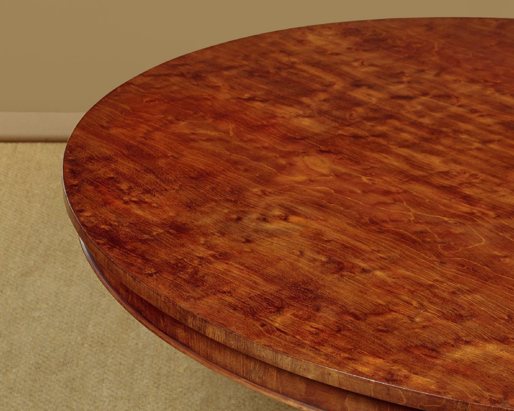 An early Victorian circular mahogany breakfast table with a central pedestal and lobed base supported by scroll feet on brass castors. View IV