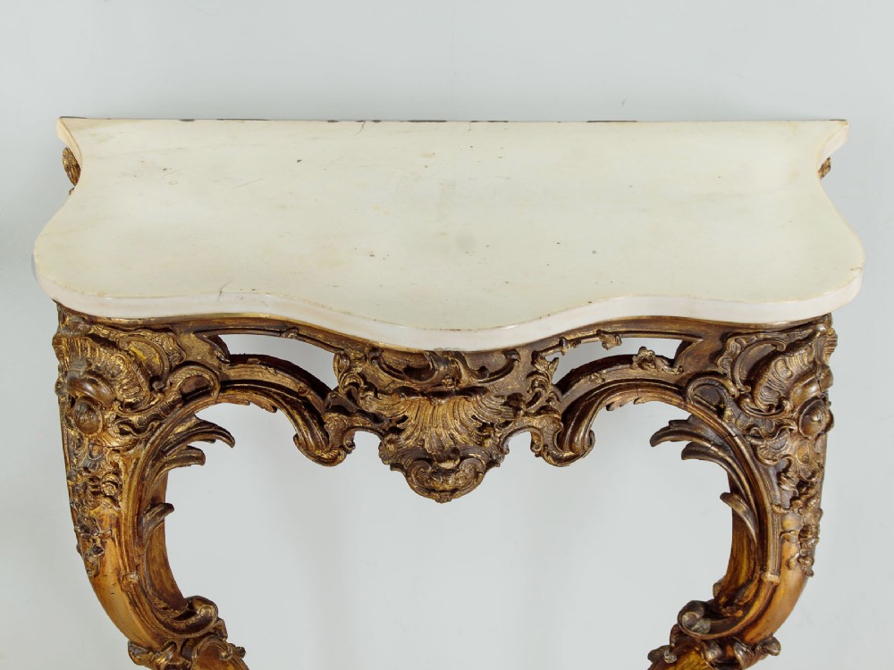 A late 19th-century Rococo Revival giltwood console table featuring carved scrollwork, two cabriole legs, and a shaped white marble top. View III