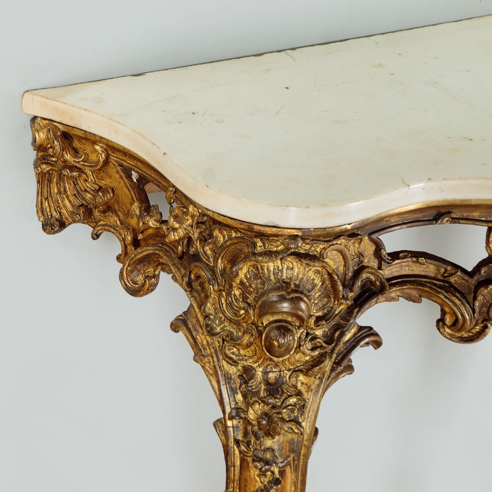 A late 19th-century Rococo Revival giltwood console table featuring carved scrollwork, two cabriole legs, and a shaped white marble top. View V