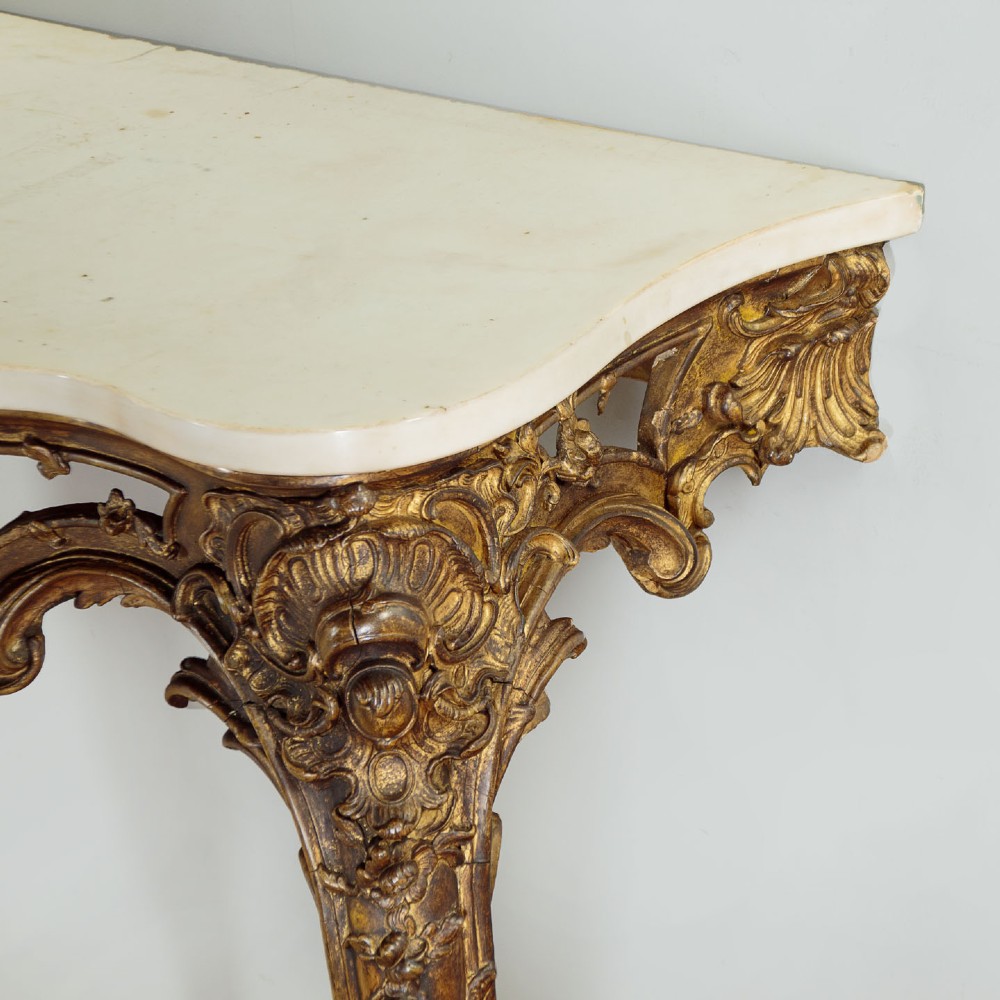 A late 19th-century Rococo Revival giltwood console table featuring carved scrollwork, two cabriole legs, and a shaped white marble top. View VI