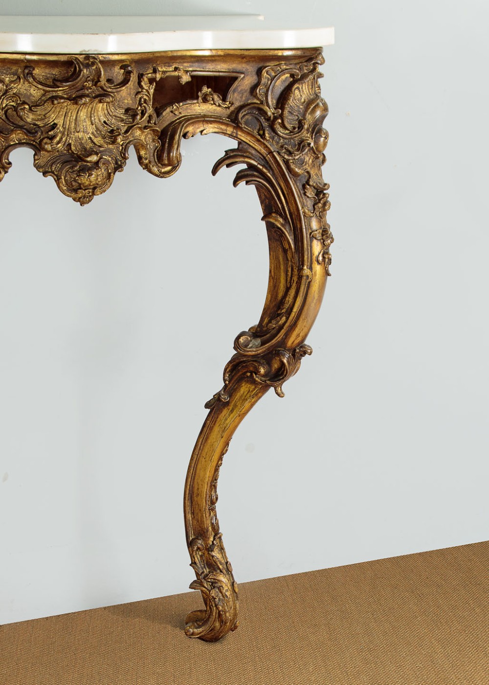 A late 19th-century Rococo Revival giltwood console table featuring carved scrollwork, two cabriole legs, and a shaped white marble top. View VIII