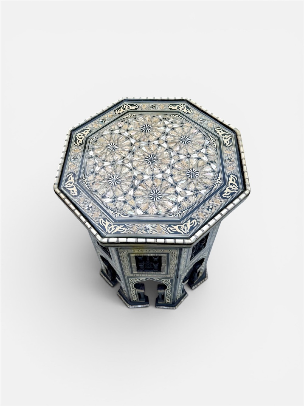 A 19th-century octagonal side table constructed from dark wood intricately inlaid with geometric mother-of-pearl star patterns and arched apron motifs. View V