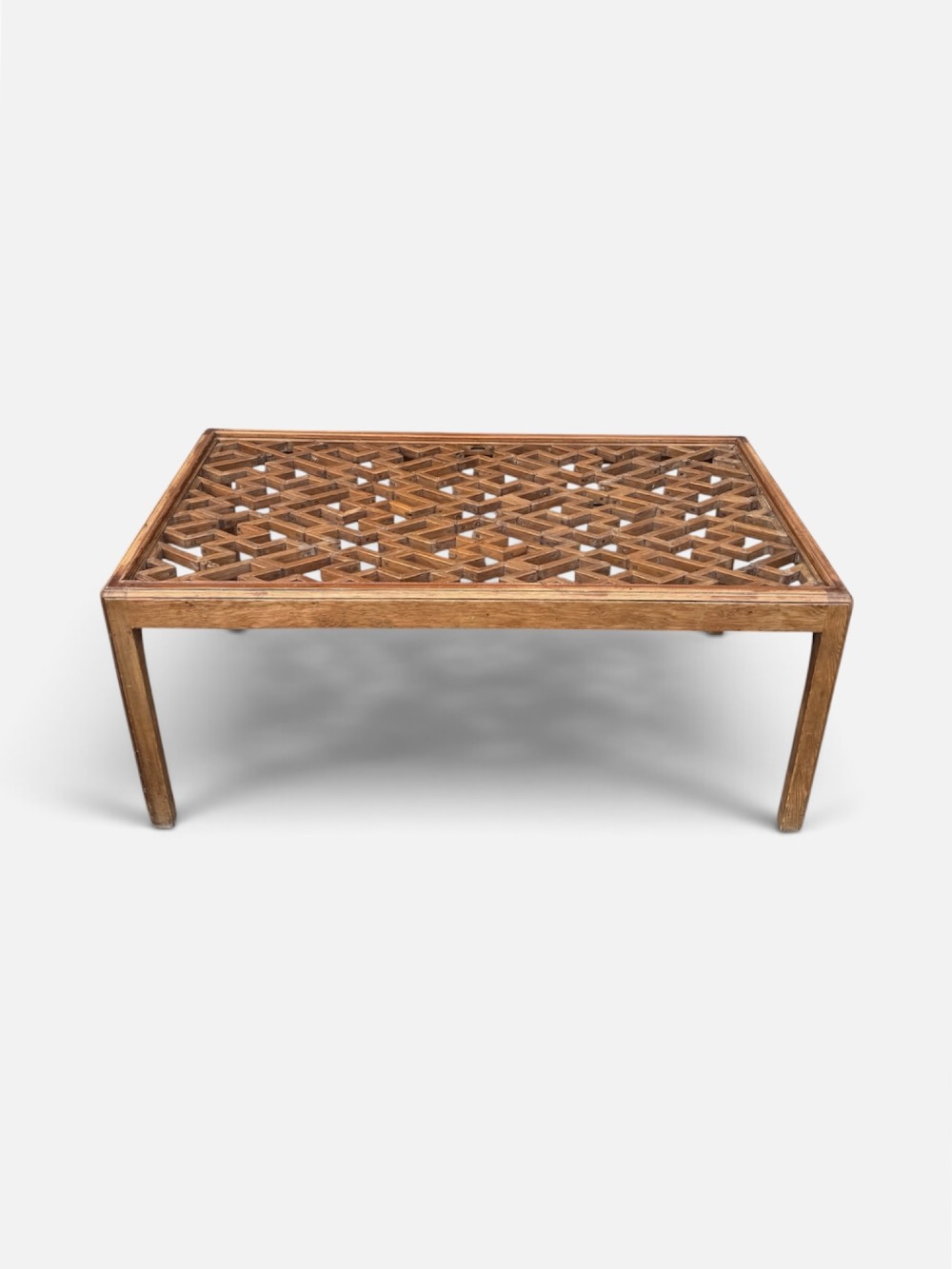 A rectangular low coffee table crafted from warm brown wood featuring an intricate geometric Chinese fretwork panel set beneath a clear glass top. View II