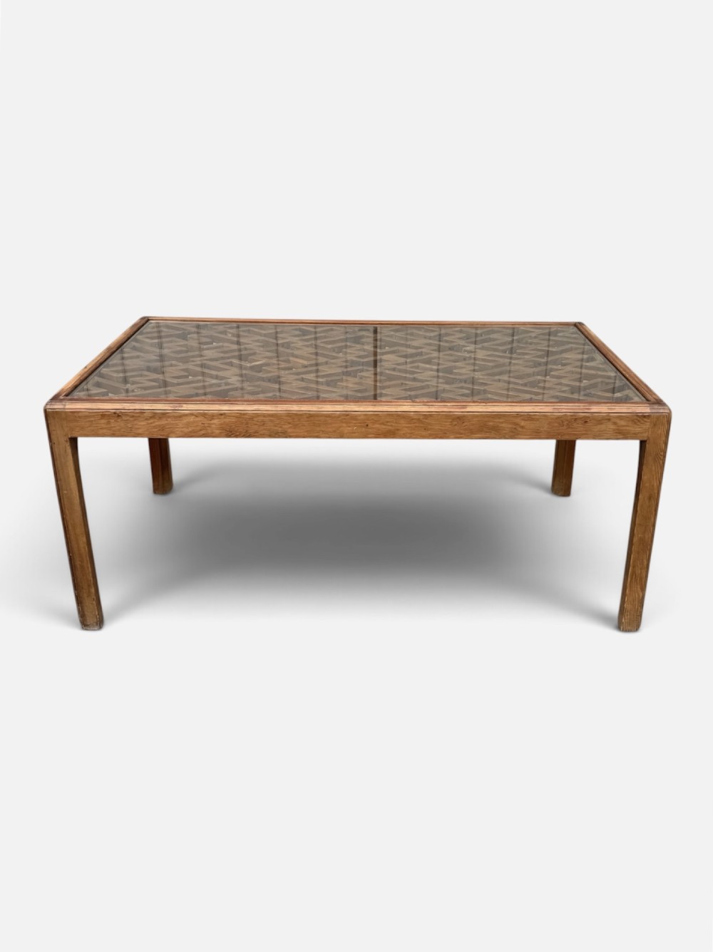 A rectangular low coffee table crafted from warm brown wood featuring an intricate geometric Chinese fretwork panel set beneath a clear glass top. View VI
