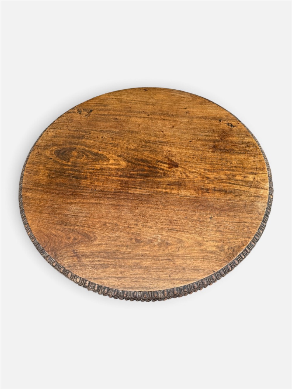 A 19th-century circular Anglo-Indian rosewood centre table featuring a carved foliate frieze, turned pedestal support, and a four-point carved platform base. View VIII
