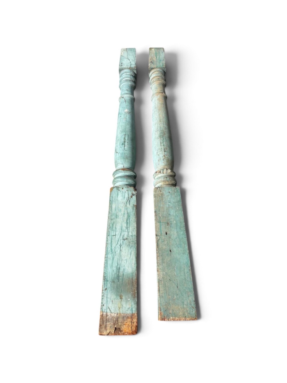 A pair of 19th-century turned hardwood architectural columns featuring a weathered blue-green painted finish.