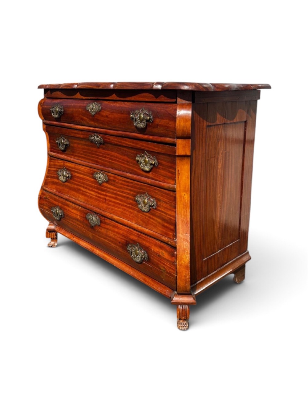 An 18th-century Dutch Colonial solid satinwood bombe chest featuring four graduated drawers, ornate brass handles, and carved feet. View II