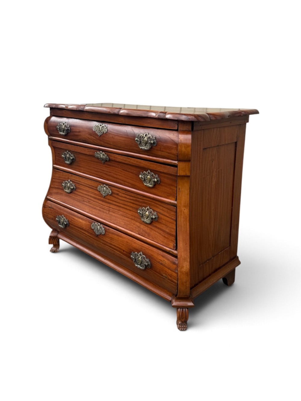 An 18th-century Dutch Colonial solid satinwood bombe chest featuring four graduated drawers, ornate brass handles, and carved feet. View IV
