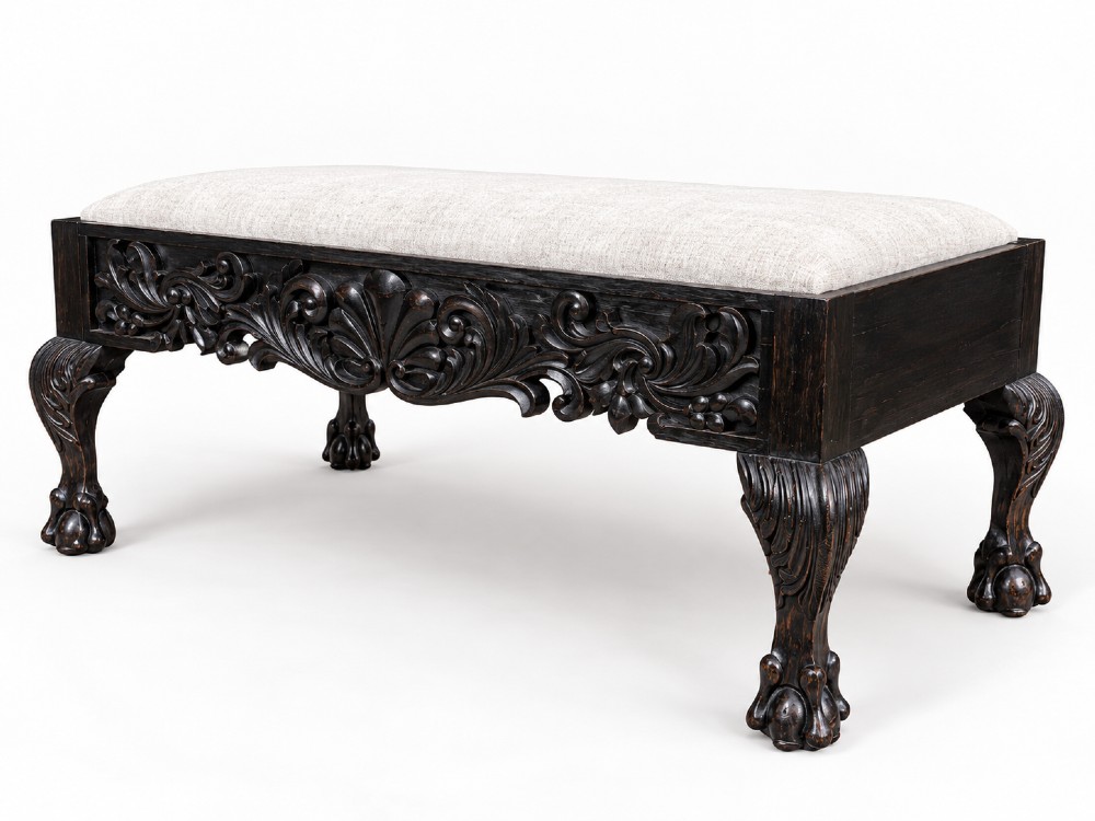A 19th-century Ceylonese calamander wood stool featuring detailed floral relief carvings on the frame, cabriole legs with claw-and-ball feet, and neutral upholstered seat.