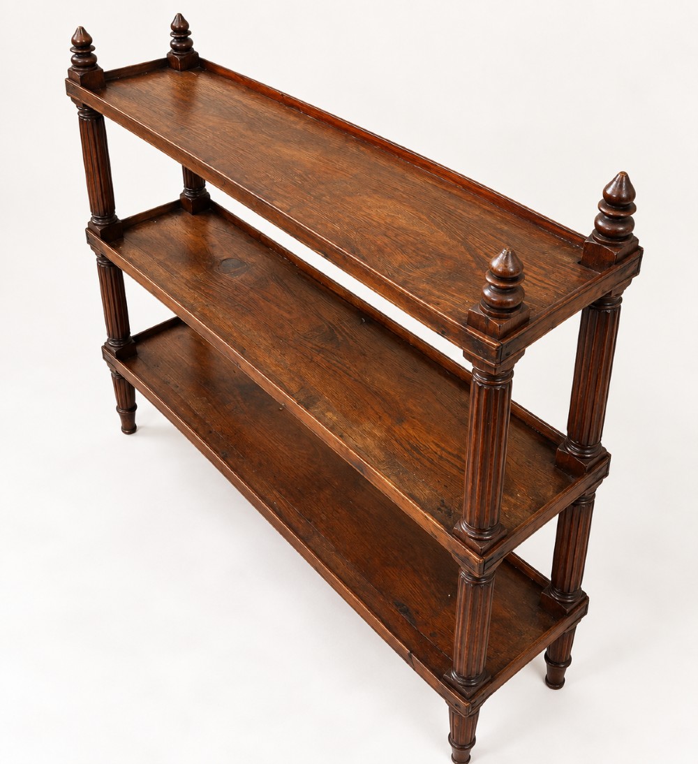 An early 19th-century dark hardwood three-tier open shelving unit featuring fluted vertical columns, turned legs, and carved top finials. View VI