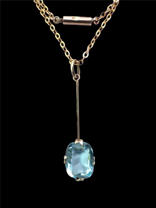 fig 1. An Edwardian 9ct gold fine chain necklace featuring a linear bar drop suspending a blue paste aquamarine gemstone.