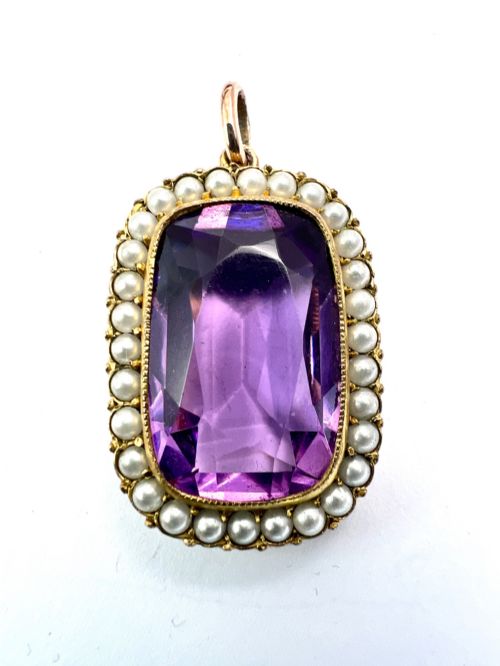 fig 1. A Victorian rectangular cushion-cut purple paste stone pendant surrounded by a halo of small white seed pearls in a gold mount.